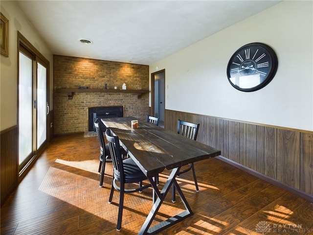 dining area featuring dark hardwood / wood-style floors, plenty of natural light, and brick wall