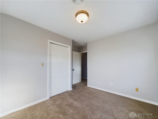 unfurnished bedroom with a closet and carpet floors