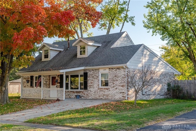 cape cod house with a front yard and a porch