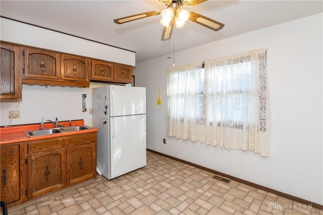 kitchen with ceiling fan, white refrigerator, and sink