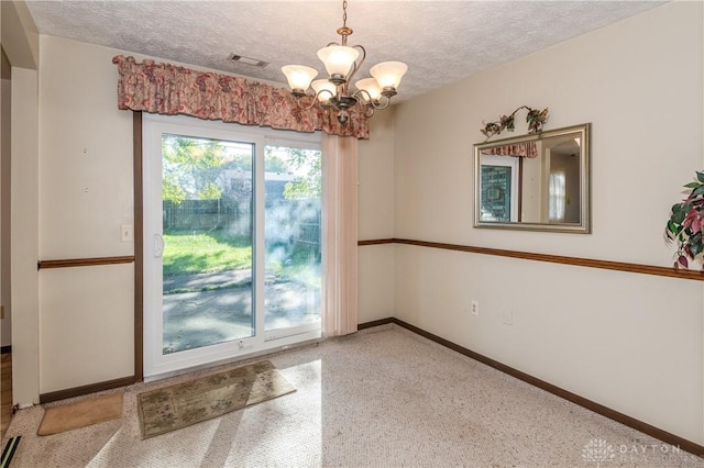 interior space with a chandelier and a textured ceiling