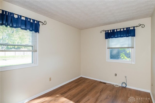 empty room featuring a textured ceiling and hardwood / wood-style flooring