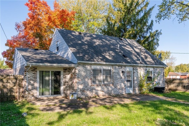 back of property with a yard and a patio