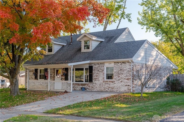 new england style home with a porch and a front lawn