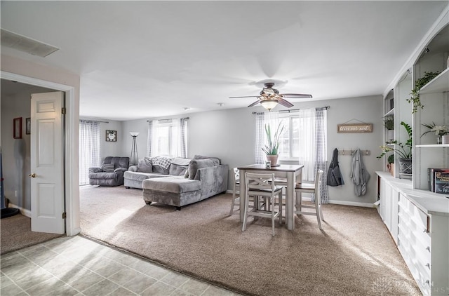 dining room featuring light colored carpet, plenty of natural light, and ceiling fan