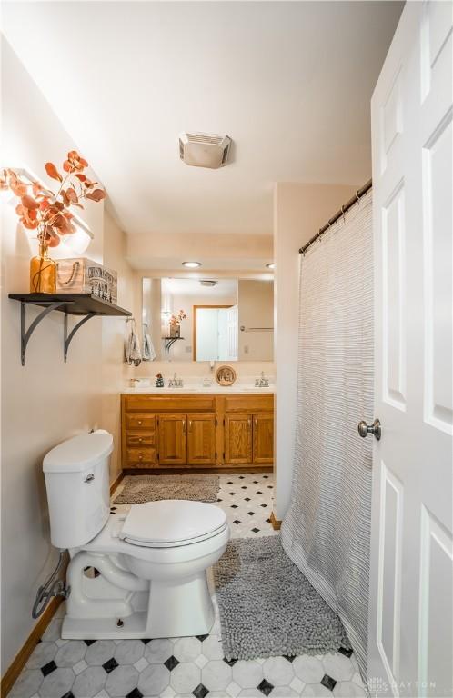 bathroom featuring tile patterned floors, vanity, and toilet