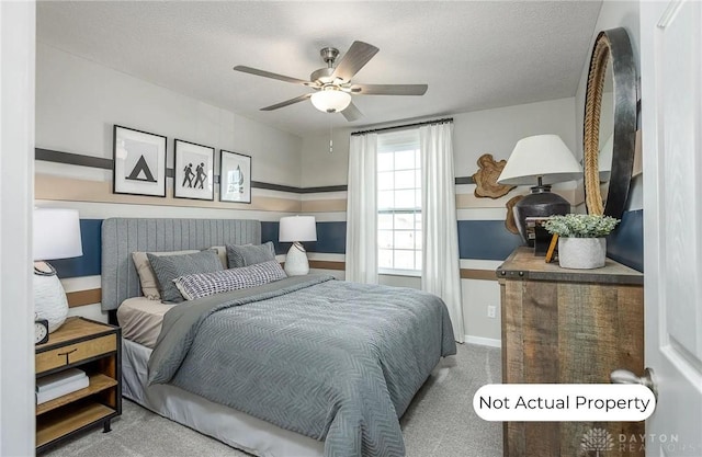 carpeted bedroom with ceiling fan and a textured ceiling