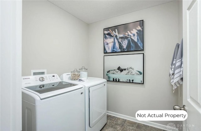 washroom featuring washer and clothes dryer and a textured ceiling