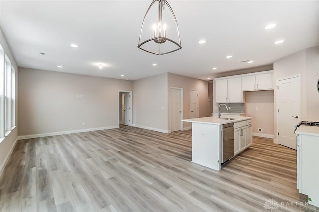 kitchen featuring white cabinetry, dishwasher, decorative light fixtures, a kitchen island with sink, and light wood-type flooring