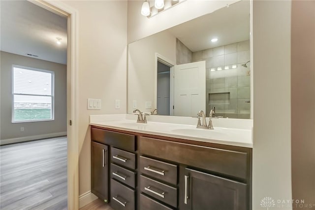 bathroom featuring hardwood / wood-style floors, vanity, and walk in shower