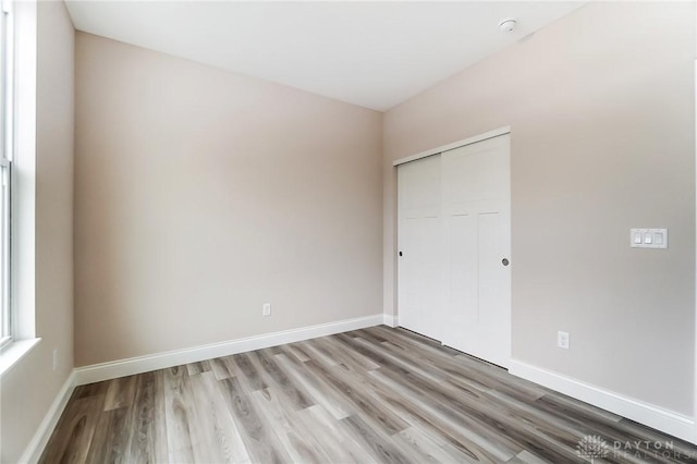 unfurnished bedroom featuring light hardwood / wood-style flooring and a closet