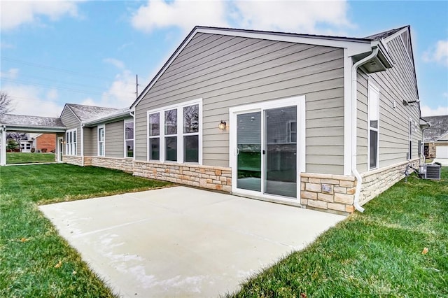 rear view of property featuring a lawn, a patio area, and central AC unit