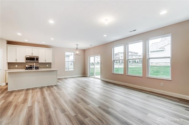 unfurnished living room featuring light hardwood / wood-style floors and a wealth of natural light