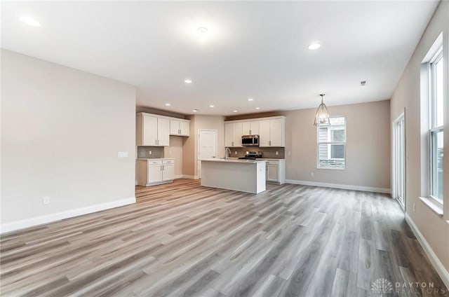 unfurnished living room featuring light wood-type flooring and sink