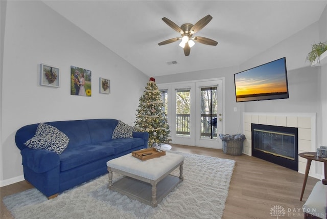 living room with a fireplace, ceiling fan, hardwood / wood-style floors, and lofted ceiling