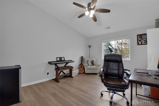 home office with ceiling fan, light hardwood / wood-style flooring, and vaulted ceiling