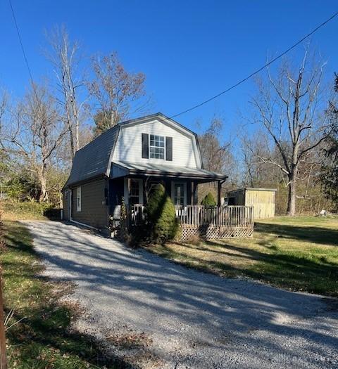 view of side of property with covered porch and a lawn