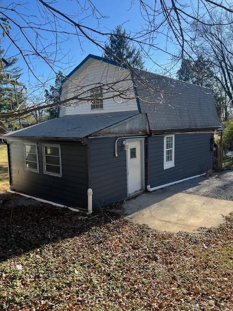 rear view of property featuring a patio area and a gambrel roof