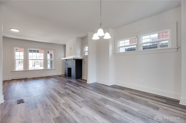 unfurnished living room featuring hardwood / wood-style floors, a healthy amount of sunlight, and a fireplace