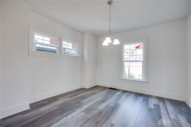 empty room featuring hardwood / wood-style floors and a chandelier