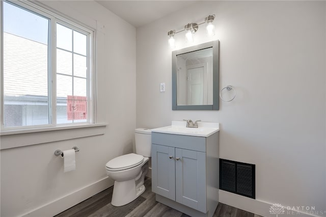 bathroom with vanity, toilet, and wood-type flooring