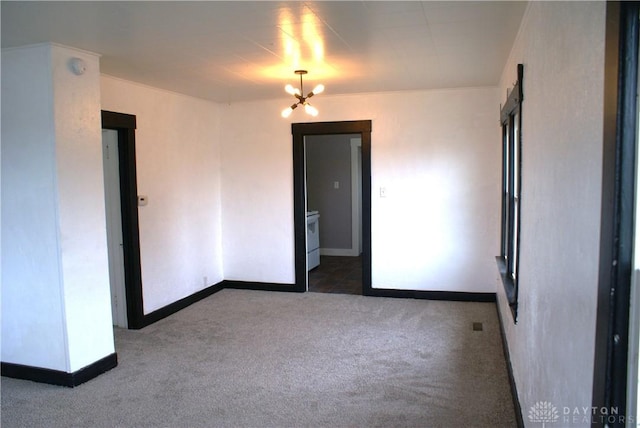 carpeted empty room with a notable chandelier