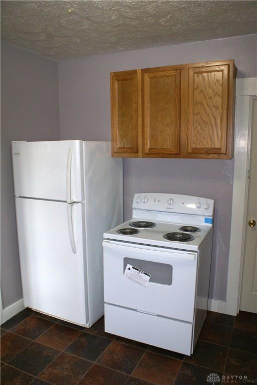 kitchen featuring a textured ceiling and white appliances