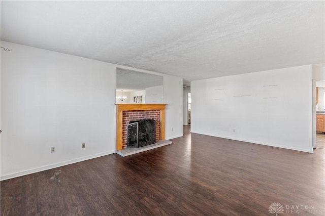 unfurnished living room with a textured ceiling, dark hardwood / wood-style floors, and a fireplace