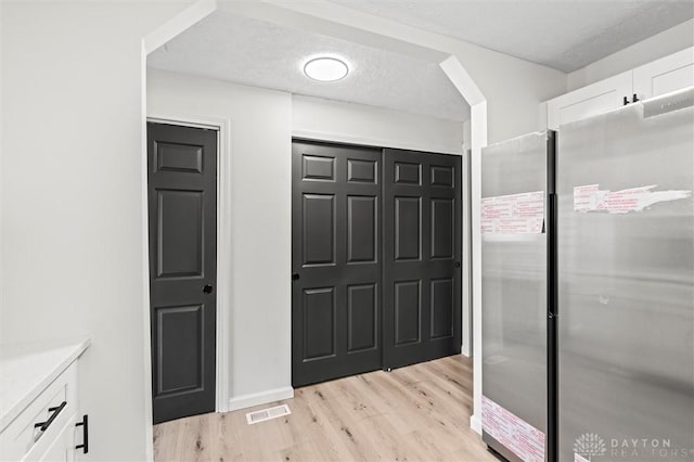 bathroom featuring visible vents, a textured ceiling, and wood finished floors