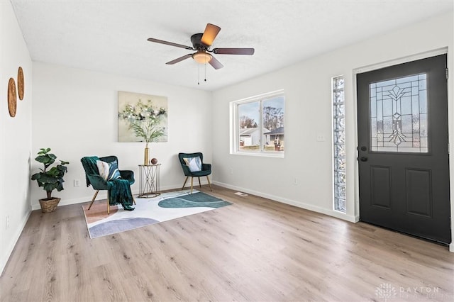 foyer featuring light wood-style floors, baseboards, and a ceiling fan