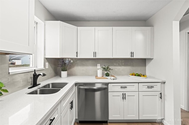 kitchen with white cabinets, dishwasher, sink, and tasteful backsplash