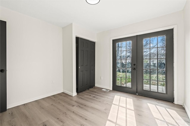 entryway with french doors, baseboards, and light wood finished floors