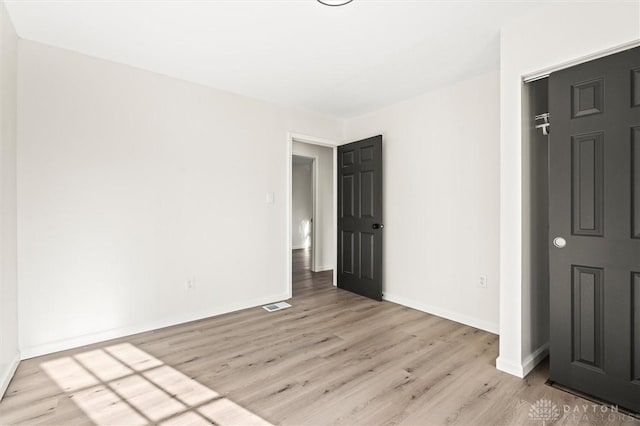 unfurnished bedroom featuring light wood-type flooring, baseboards, and visible vents