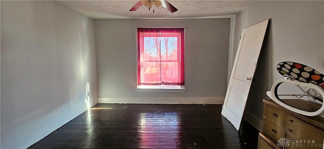 unfurnished room featuring ceiling fan, dark hardwood / wood-style flooring, and a textured ceiling