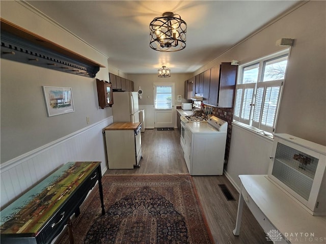 laundry area featuring washer / dryer, light wood-type flooring, a wealth of natural light, and an inviting chandelier