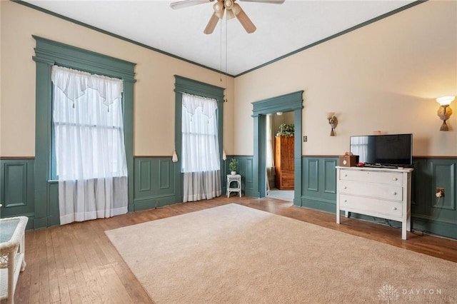 bedroom with hardwood / wood-style flooring, ornamental molding, and ceiling fan