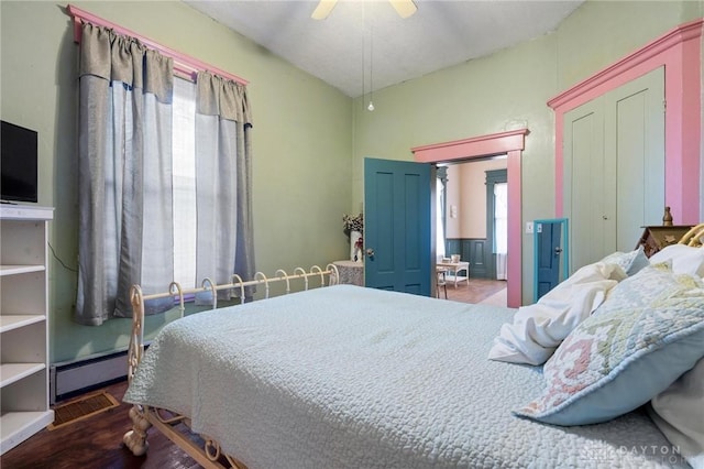 bedroom with ceiling fan, dark hardwood / wood-style flooring, and a baseboard radiator