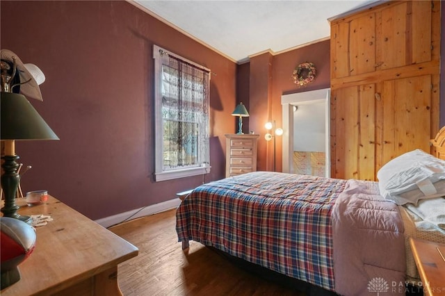 bedroom with hardwood / wood-style flooring and ornamental molding