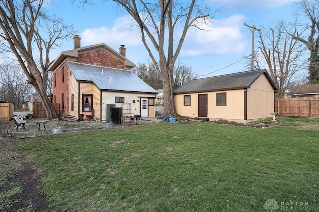 back of house featuring an outbuilding and a lawn