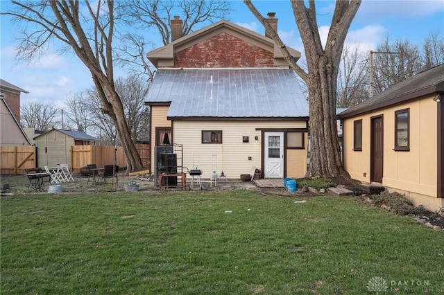 rear view of house with a lawn and a storage unit