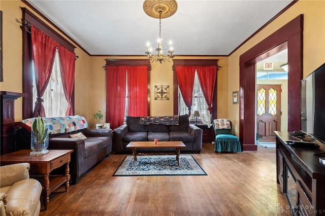 living room featuring crown molding, hardwood / wood-style floors, and an inviting chandelier