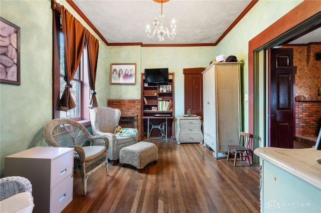 sitting room featuring an inviting chandelier, ornamental molding, and dark hardwood / wood-style flooring