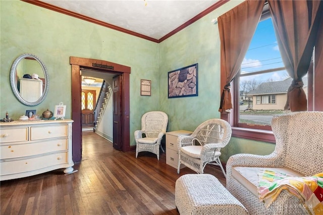 living area featuring ornamental molding and dark hardwood / wood-style flooring