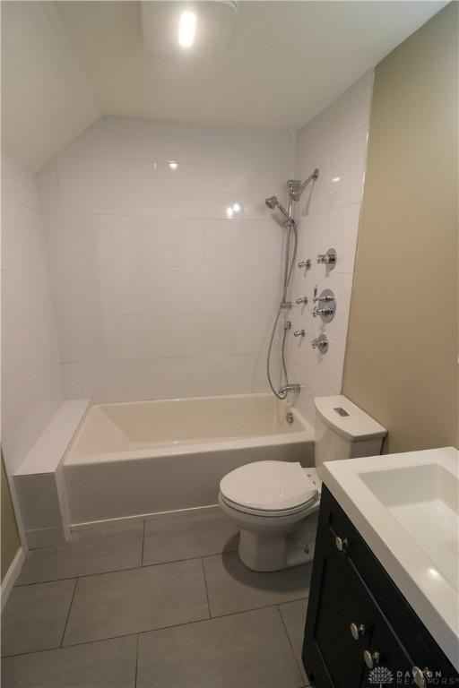 full bathroom featuring tile patterned flooring, vanity, toilet, and tiled shower / bath