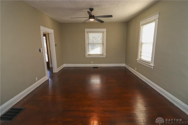 empty room with ceiling fan and dark hardwood / wood-style flooring