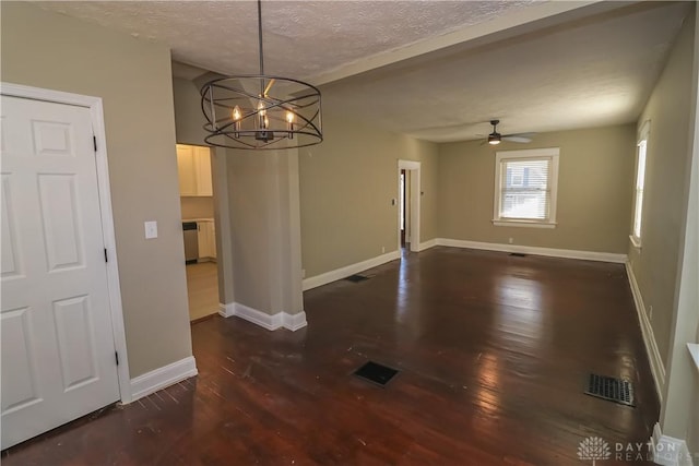 unfurnished dining area featuring ceiling fan with notable chandelier, dark hardwood / wood-style flooring, and a textured ceiling