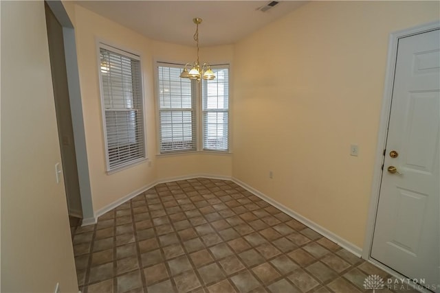 tiled empty room featuring a notable chandelier