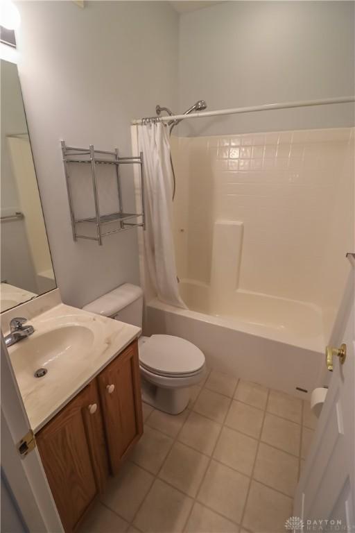 full bathroom with tile patterned floors, shower / bath combo, toilet, and vanity