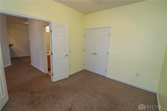 unfurnished bedroom with dark carpet and a closet