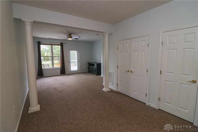 unfurnished living room with carpet flooring, ornate columns, and ceiling fan